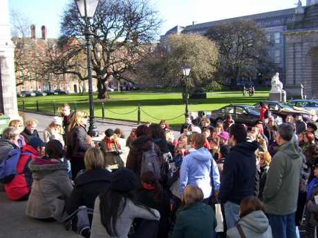 Click on image to see full-sized version Carol talking to the first tour at Trinity College. In the background is the statue of Provost Salmon, who famously said that women would be admitted to Trinity College over his dead body.