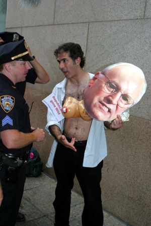 Protestor explains to cop that though masks are illegal in NYC, cardboard is not *really* a mask